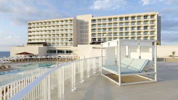 Un hôtel doté d’une piscine, de chaises longues et d’un cabanon.