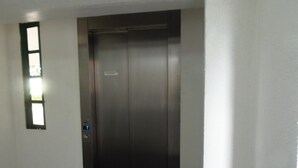 A closed elevator door with a control panel on the wall. - Hotel Guaíba (Guaiba)