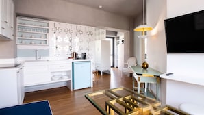 Eine moderne Küche mit weißen Schränken, einem blauen Kühlschrank und einem Essbereich mit einem Glastisch und Stühlen.