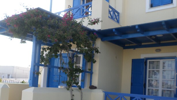 Een gebouw met blauwe luiken en een balkon.