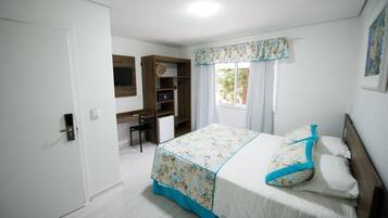 Un dormitorio con cama, escritorio y armario.