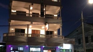A multi-story hotel with balconies, a ground-level restaurant, and a visible sign for 'BROOKES SUN'. - Hotel Midnight (Paramaribo)
