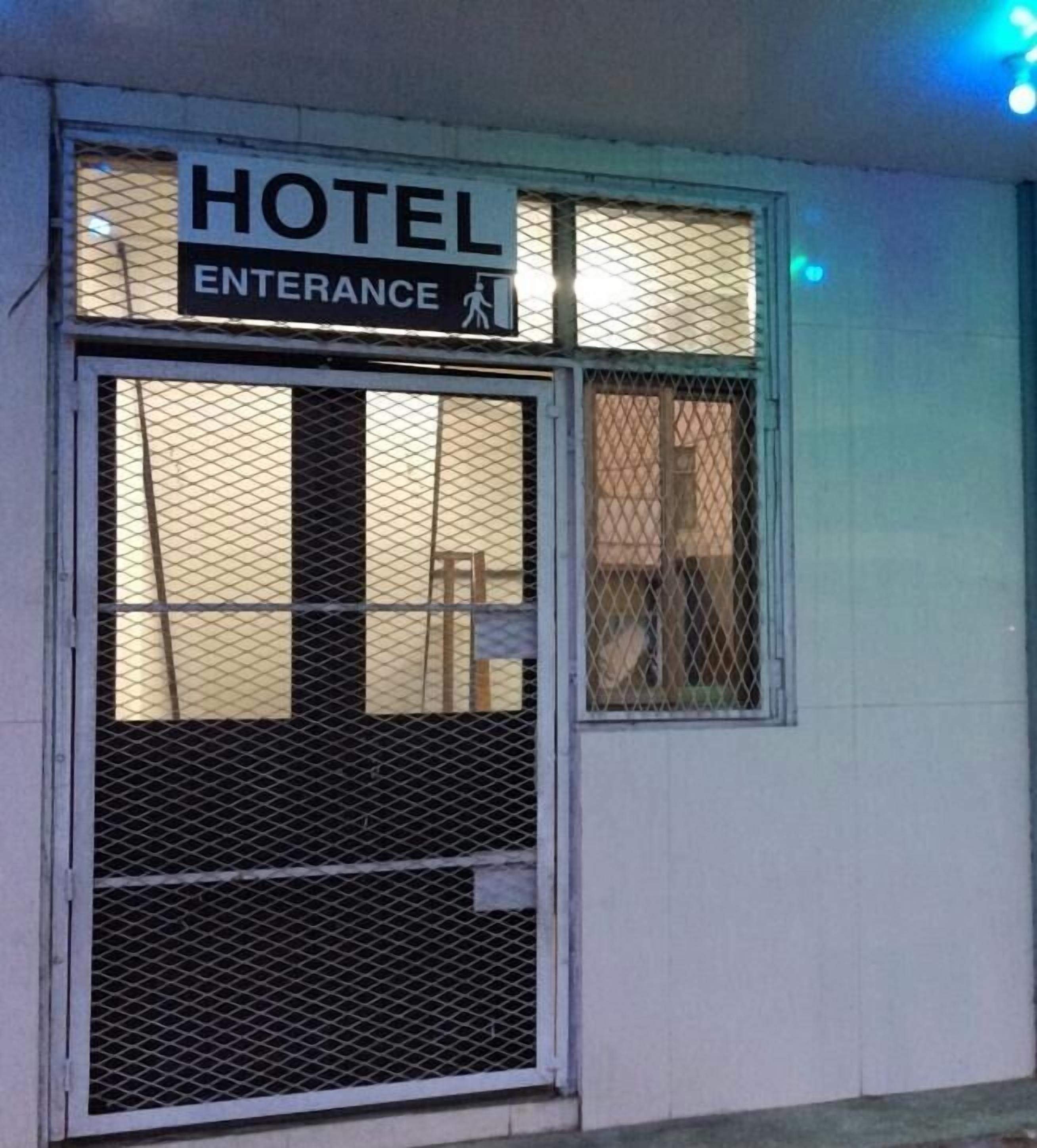 A hotel entrance with a sign indicating the direction to the entrance.