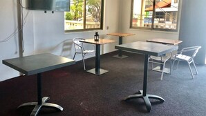 A conference room with a large table, two smaller tables, and four chairs. - Hotel Midnight (Paramaribo)