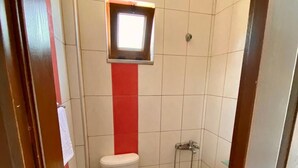 A small bathroom with a toilet, a shower, and a sink. - Uysal Pansiyon (Bozcaada)
