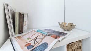 A white shelf with books, a magazine, and a decorative metal bowl. - Italianway Easy - Vigevano 13 (Milan)