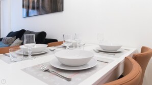 A dining table set with white plates, bowls, and glasses, with a placemat featuring icons. - Italianway Easy - Vigevano 13 (Milan)