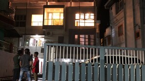 A building with multiple illuminated windows and a gated entrance. - Hotel Value (Port Blair)