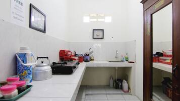 A small kitchen with a sink, kettle, and various kitchen items.