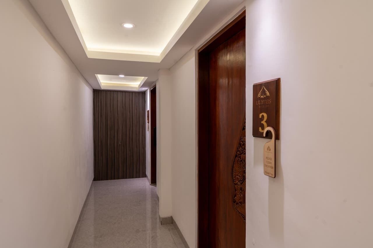 A hotel hallway with a wooden door labeled "Hotel 3" and a sign indicating "Please do not block the door."