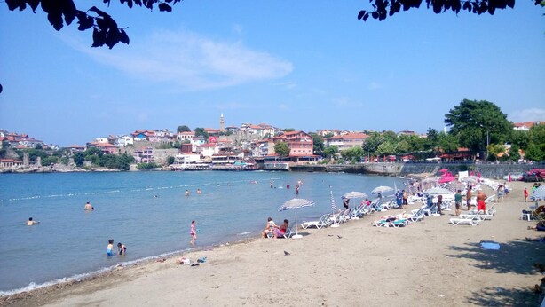 A beach with people swimming and sunbathing, umbrellas, and beach chairs. - Kerem Apart Pansiyon (Amasra)