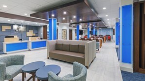 A hotel lobby with a reception desk, seating area, and a dining section. - Holiday Inn Express & Suites Purcell by IHG (Purcell)