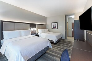 A hotel room with two beds, a desk, a TV, and a framed picture on the wall. - Holiday Inn Express & Suites Purcell by IHG (Purcell)