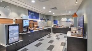 A modern breakfast area with a digital menu display, a coffee machine, and a variety of food options. - Holiday Inn Express & Suites Purcell by IHG (Purcell)