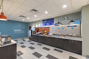 A breakfast area with a counter displaying various food options, a sign for Express Start Breakfast, and a wall with a 'Good Morning' message. - Holiday Inn Express & Suites Purcell by IHG (Purcell)