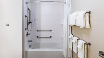 Een moderne badkamer met een inloopdouche, handgrepen en een handdoekrek.