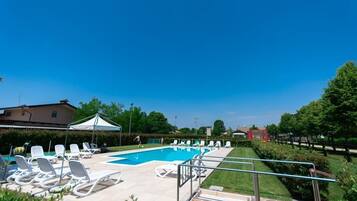 Een seizoensgebonden buitenzwembad en parasols bij het zwembad