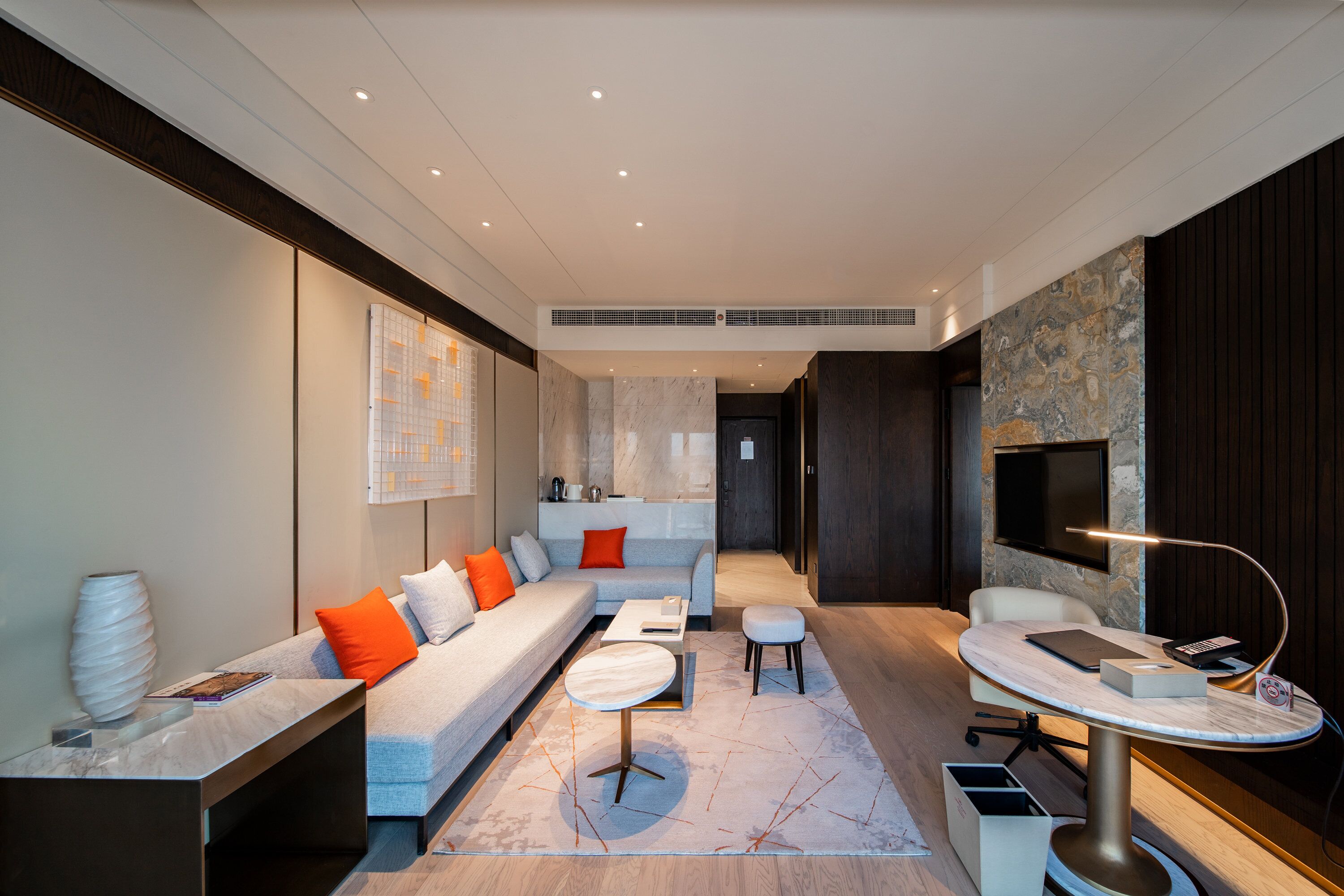 A modern living room with a sofa, coffee table, and a TV on a stand.