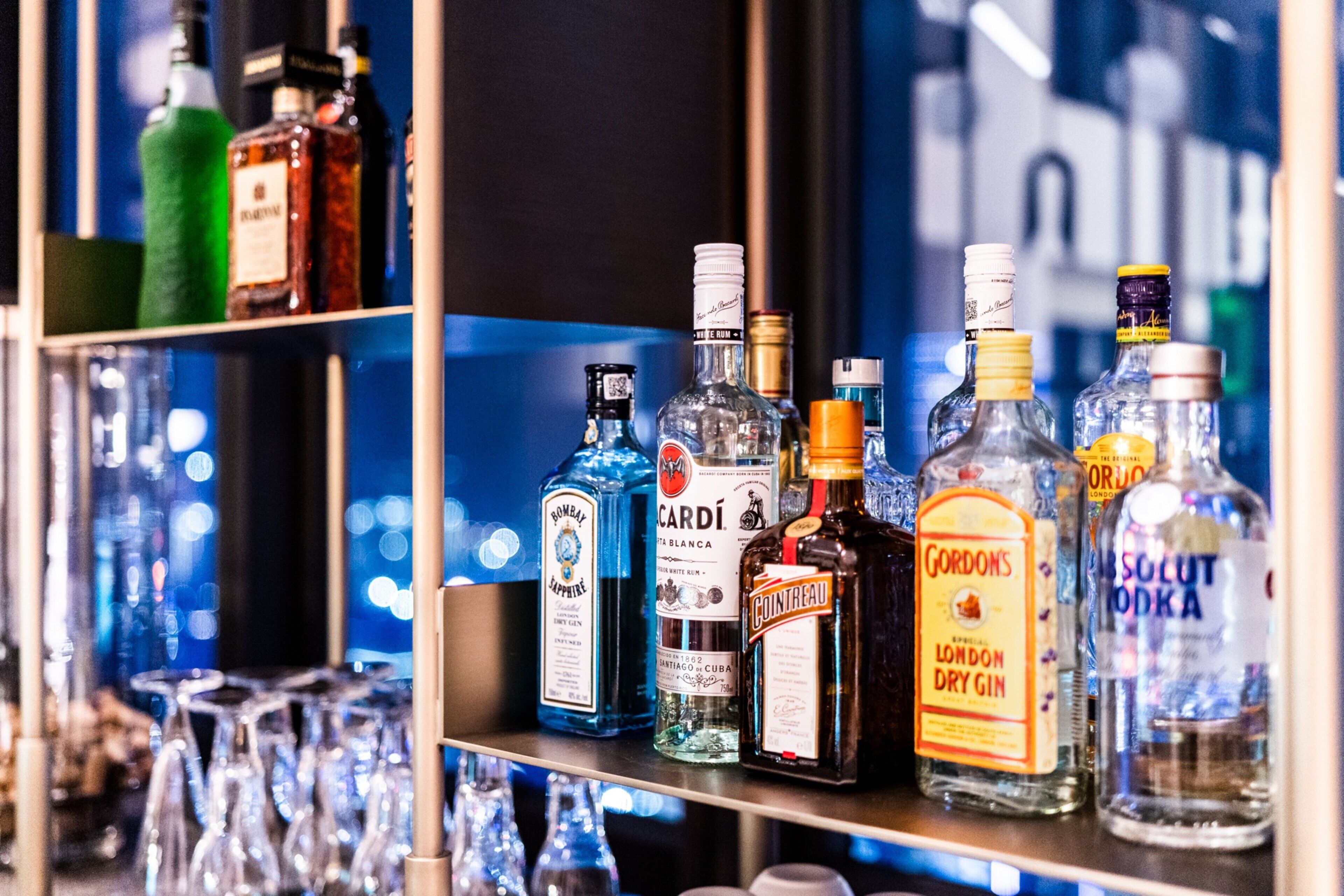 A bar with shelves of various liquor bottles and glasses.