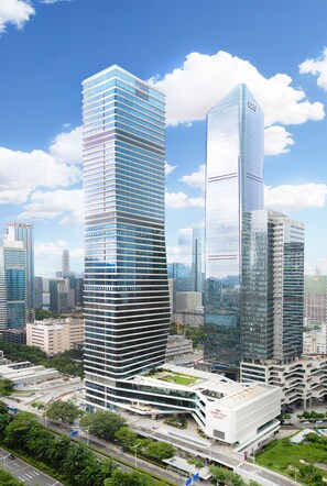 A modern high-rise building with a unique curved design, surrounded by other skyscrapers and greenery.