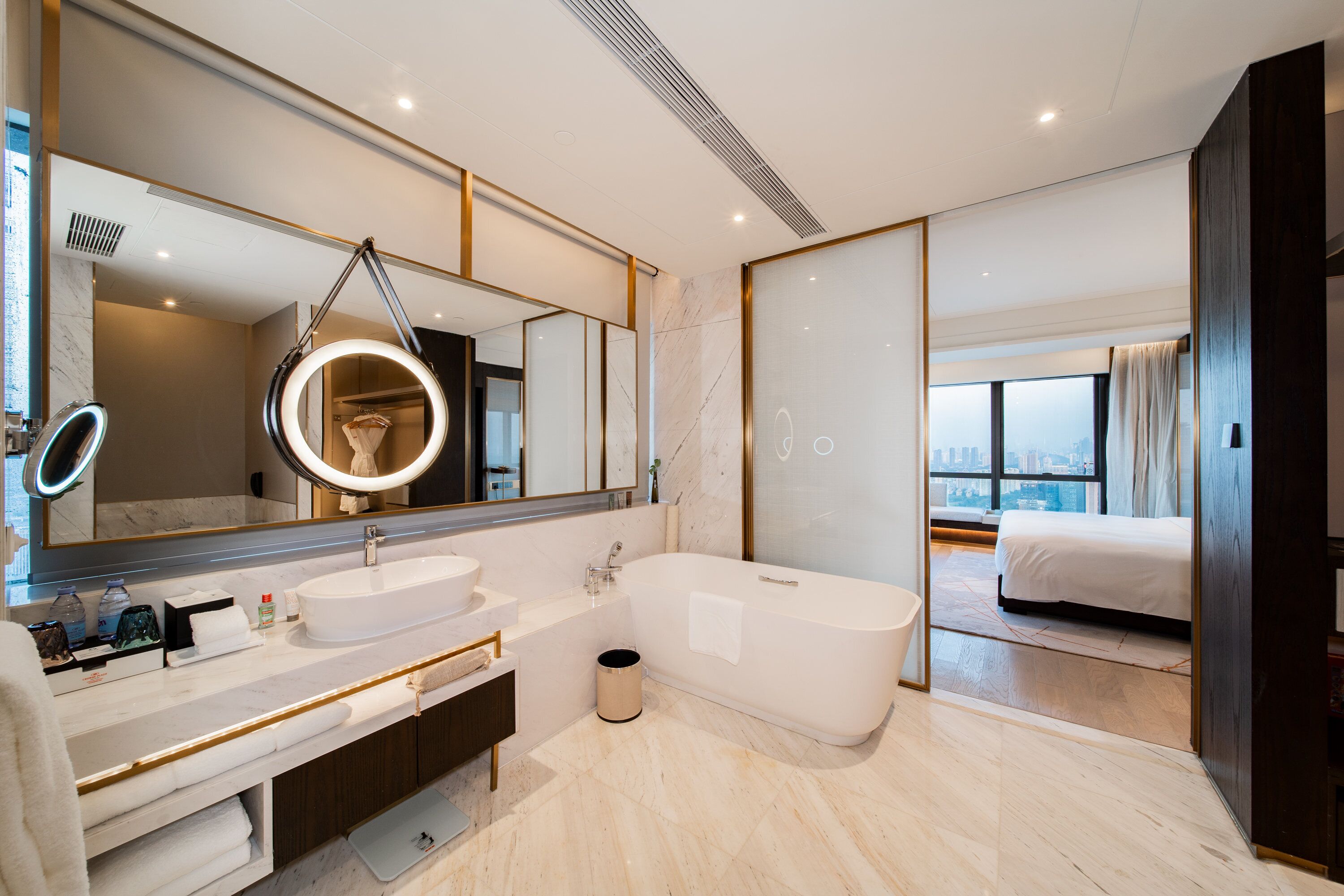 A modern bathroom with a large mirror, a bathtub, and a vanity with a sink.