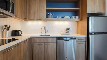Una cocina moderna con armarios de madera, electrodomésticos de acero inoxidable y una pared azul de acento.