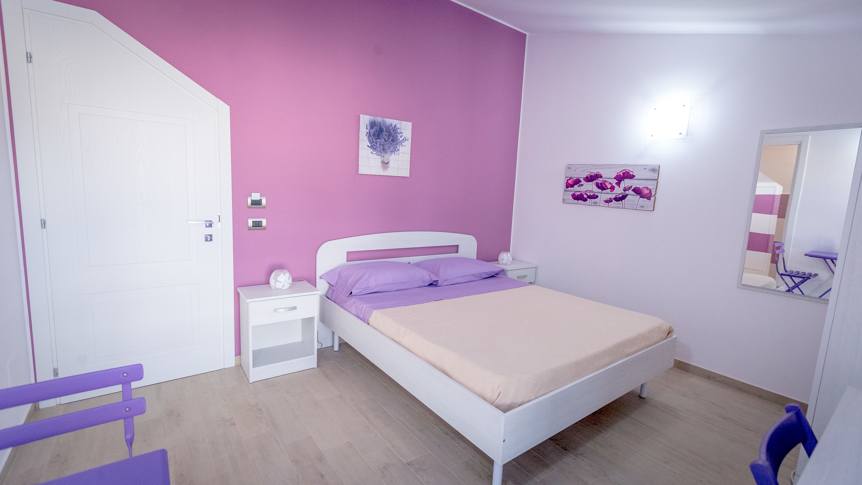 A bedroom with a bed, nightstand, and a dresser.