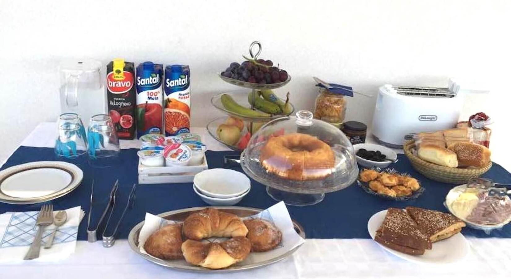 A breakfast buffet with various food items, including pastries, fruits, and beverages.