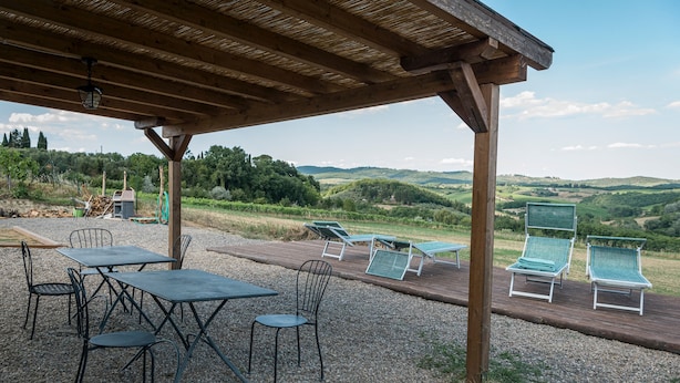 Un espace extérieur abrité, doté de tables et de chaises, offrant une vue sur un paysage pittoresque.