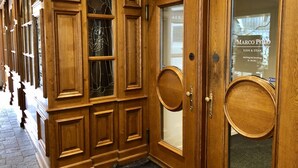 A wooden entrance with a glass door displaying the name "Marco Polo" and a sign indicating "Sushi & Steak" available from Monday to Sunday, 8-24 Uhr. - Marco Polo Business Apartments Sonne - Bremgarten (Bremgarten)