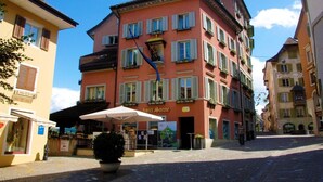 A multi-story hotel with a red facade, a balcony, and a sign reading "Hotel Sonne". - Marco Polo Business Apartments Sonne - Bremgarten (Bremgarten)