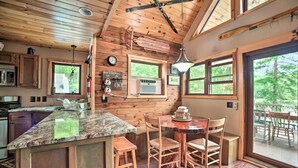 Ein Ferienhaus-Interieur mit Küche, Essbereich und großen Fenstern.
