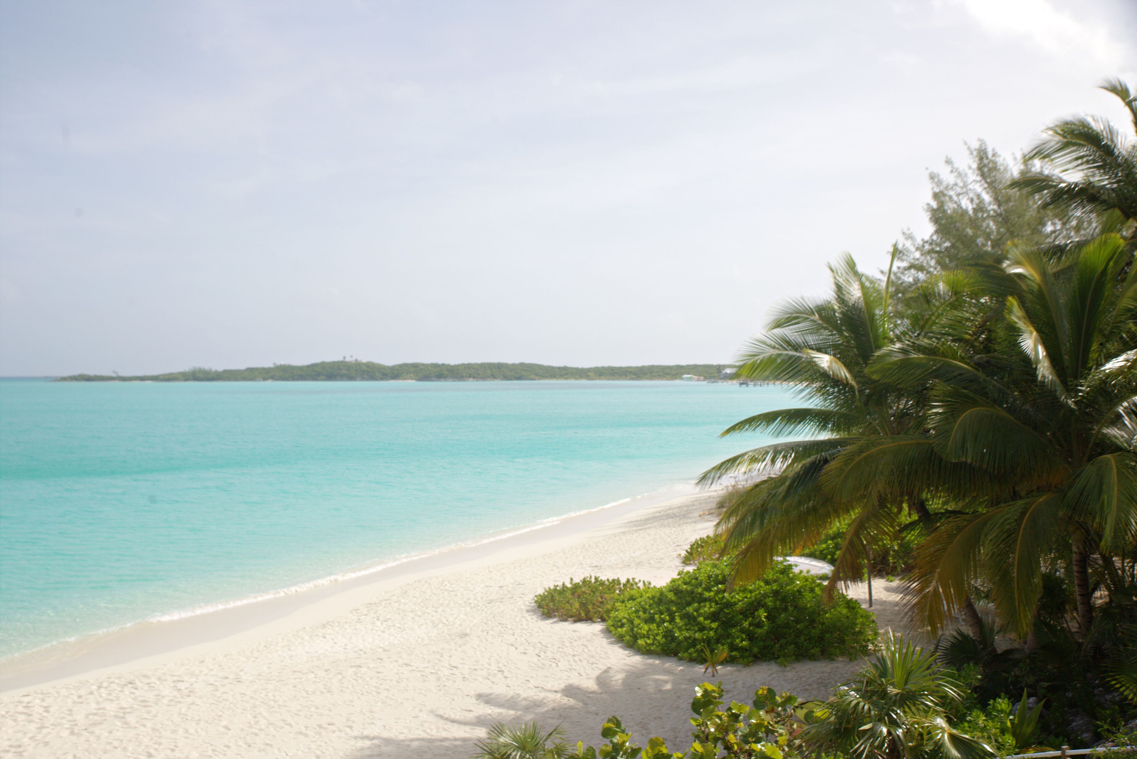 A beach with white sand and clear turquoise water.