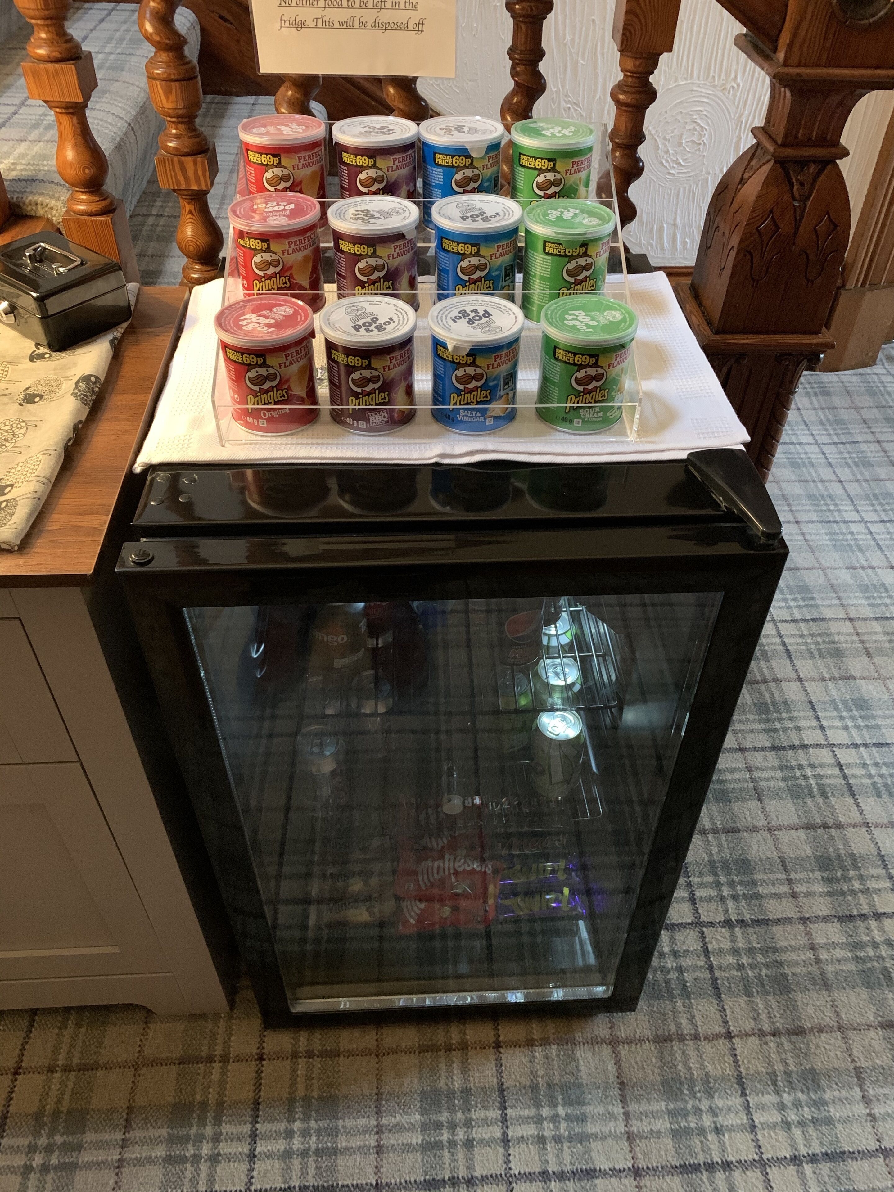 A refrigerator stocked with Pringles cans in various flavors.