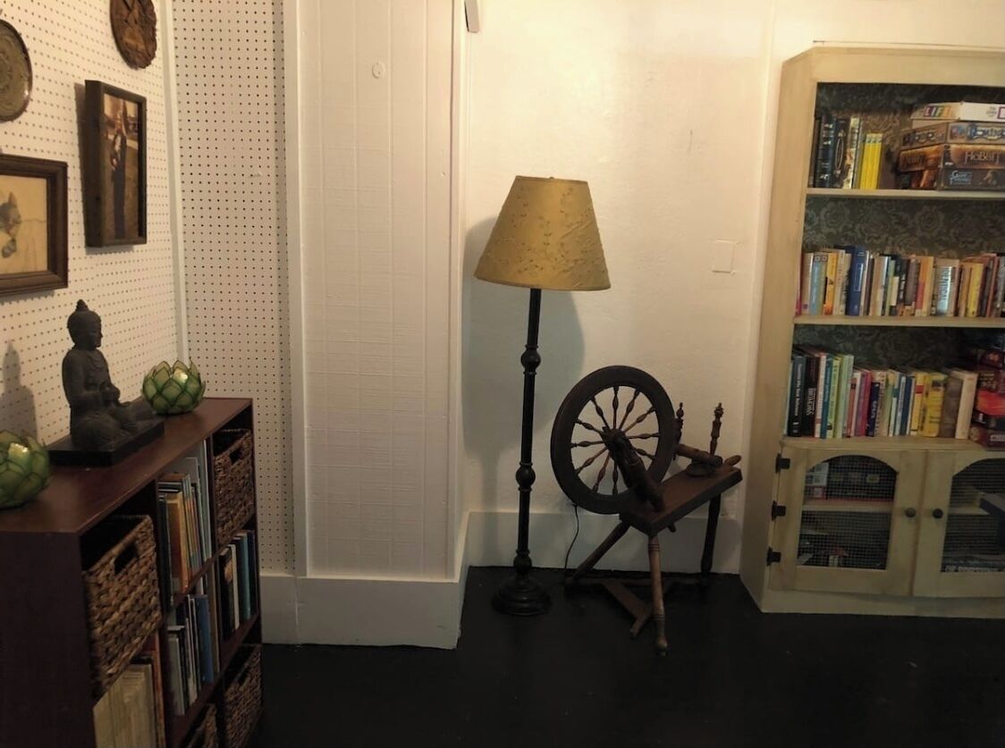 Een kamer met een boekenkast, een lamp en een draaischijf.