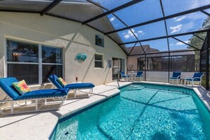 Une piscine couverte avec des chaises longues et une pergola.