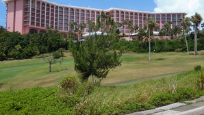 A large, multi-story hotel with a pink facade and numerous balconies.
