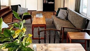 Una sala de estar acogedora con un sofá, sillas, una mesa de centro y una estantería.