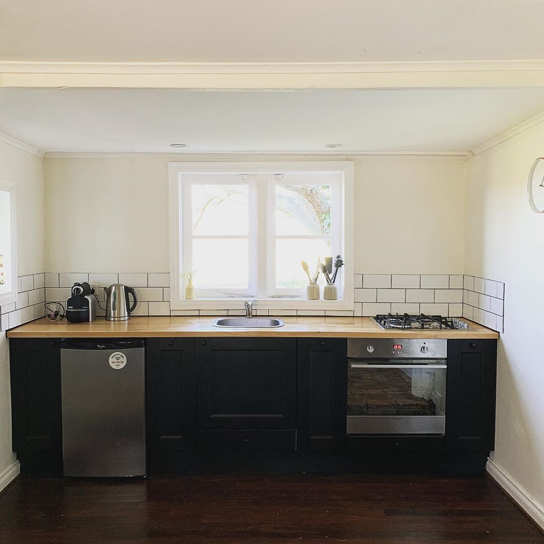 A compact kitchen with a dishwasher, stove, and sink.
