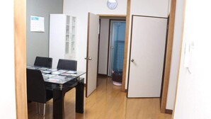 A room with a dining table, chairs, a cabinet, and a door leading to another room. - Self-catering with Wi-fi and amenities. 10 minutes from JR Kasuga Station. MIYUKIHOUSE302 (春日市)