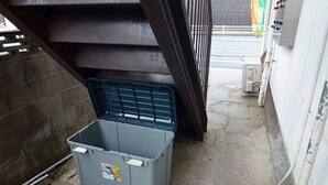 A grey storage bin under a staircase. - Self-catering with Wi-fi and amenities. 10 minutes from JR Kasuga Station. MIYUKIHOUSE302 (春日市)