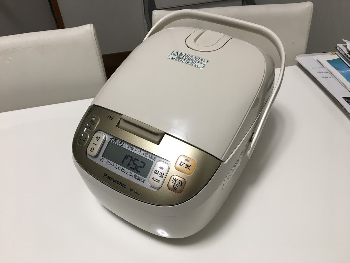 Un cuiseur à riz Panasonic sur une table blanche.