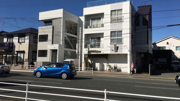 A modern building with multiple floors, a visible garage, and a clear sky. - Self-catering with Wi-fi and amenities. 10 minutes from JR Kasuga Station. MIYUKIHOUSE302 (春日市)