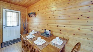 A wooden interior with a dining table set for four, a door, and a window with curtains. - Secluded Lenoir Cabin: 4 Mi to Dtwn Blowing Rock (Lenoir)