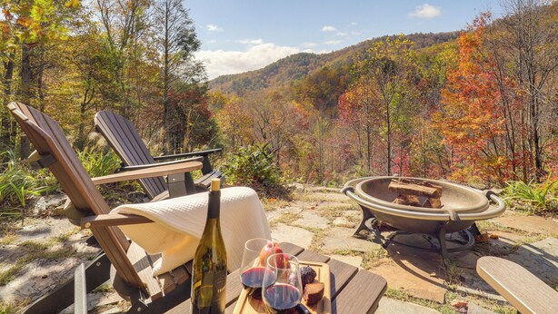 A wooden deck with a table set for a meal, a bottle of wine, and a fire pit. - Secluded Lenoir Cabin: 4 Mi to Dtwn Blowing Rock (Lenoir)