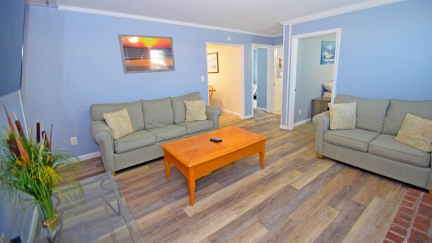 A living room with two grey sofas, a wooden coffee table, and a glass coffee table. - Holiday Cottage-Oceanside 77th St, W/D, AC, Free WIFI (Ocean City)