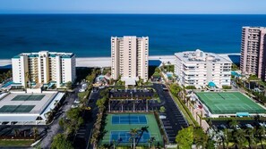 A coastal hotel complex with multiple high-rise buildings, a beach, and a tennis court. - Enjoy Paradise in this 2/2 Beachfront Condo (Marco Island)