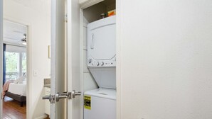 A laundry room with a white washing machine, a dryer, and a door with a handle.