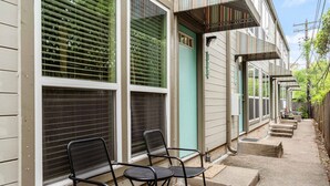 A row of houses with large windows and a covered porch area.