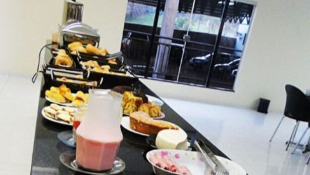 A buffet setup with various food items and condiments. - Nacional Hotel Jataí (Jatai)